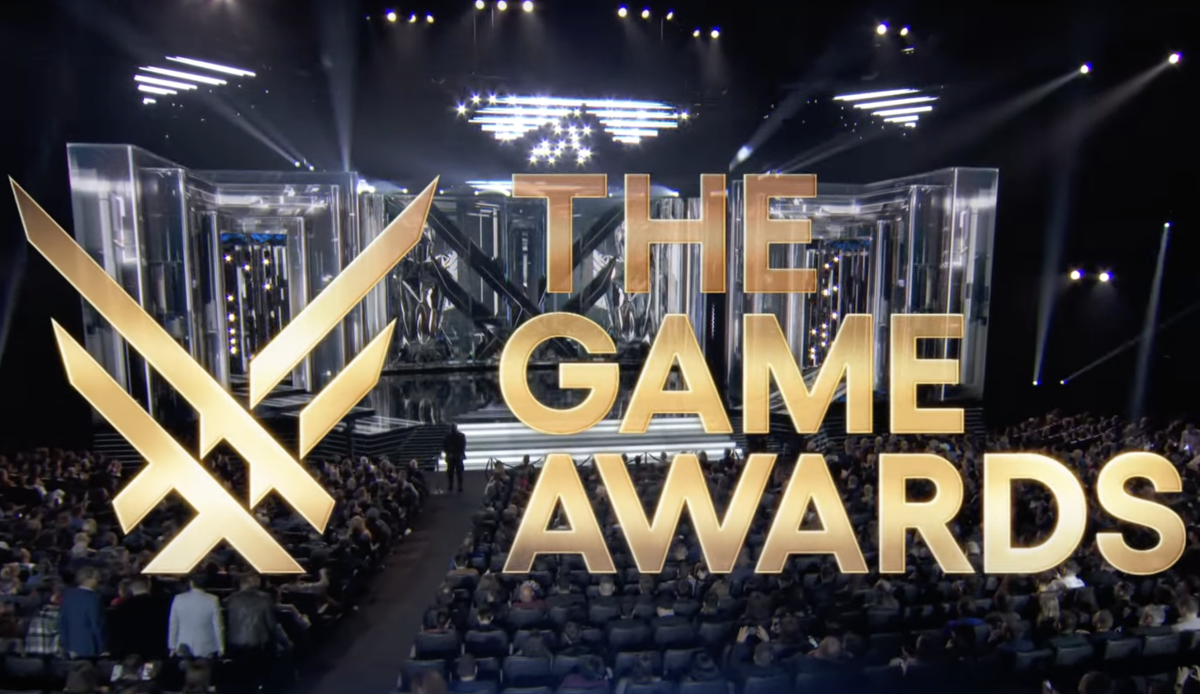 Stage setup for The Game Awards with a large audience, golden logo, and futuristic lighting, highlighting gaming’s biggest celebration