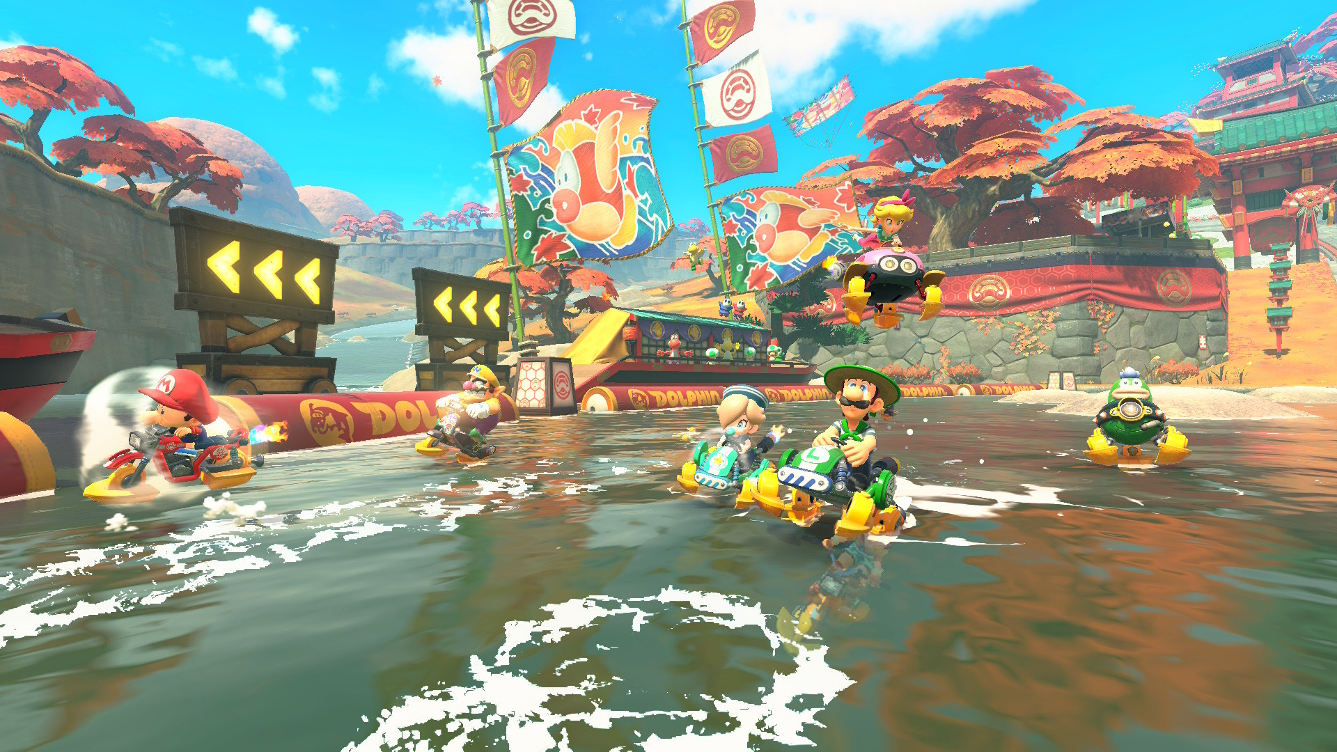 Mario, Luigi, Peach, and others racing on water in a vibrant, autumn-themed track in Mario Kart World for Nintendo Switch 2.