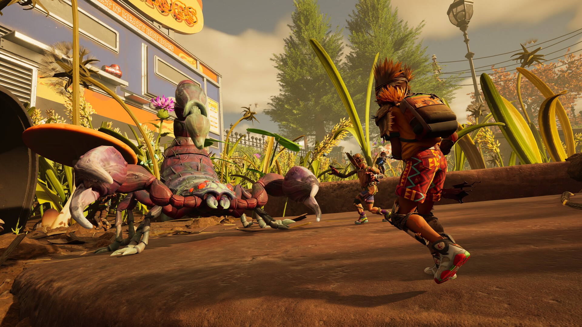 Players confront a giant scorpion outside a colourful hot dog stand in Grounded 2’s suburban garden showdown.