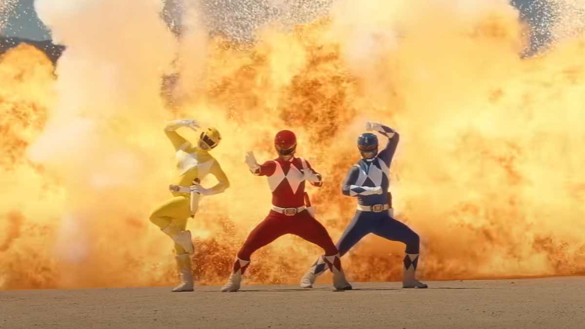 Gaming World News: Yellow, Red, and Blue Power Rangers posing heroically with a massive explosion behind them in Fortnite Chapter 6 Season 4 trailer