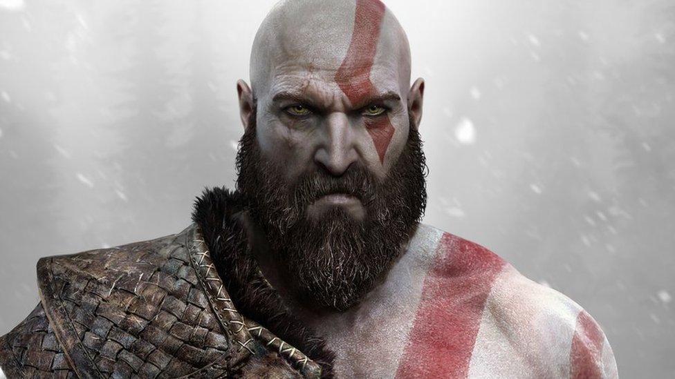 Close-up of Kratos, the main character from God of War, with red war paint and armour against a snowy backdrop