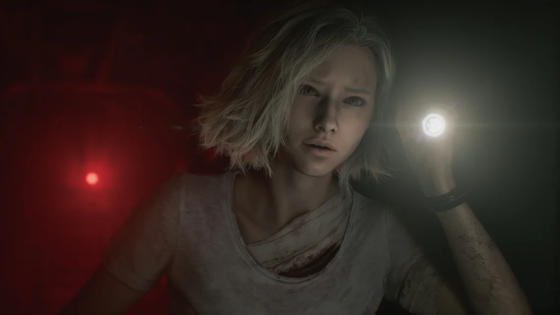 Character exploring a dark basement in Resident Evil Requiem, holding a torch with red emergency lighting in the background.