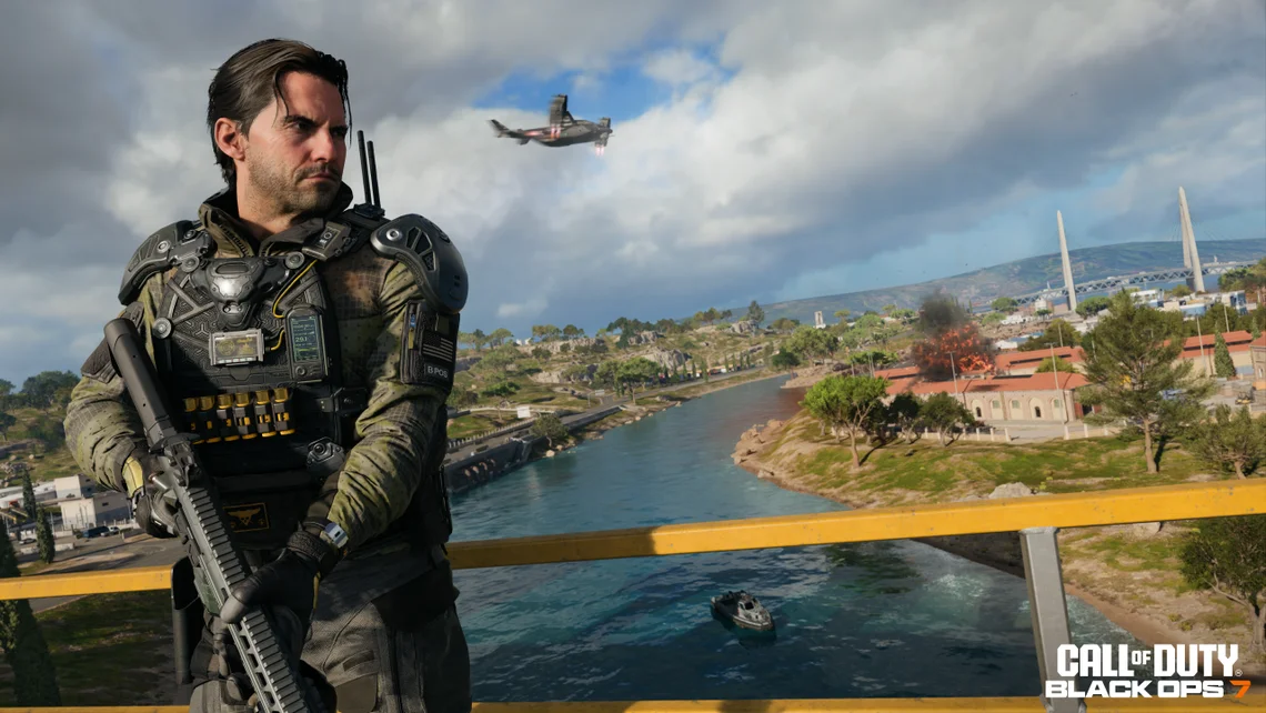 Armed soldier standing on a bridge overlooking a river and combat zone with helicopter and explosions in Call of Duty Black Ops 7 gameplay scene