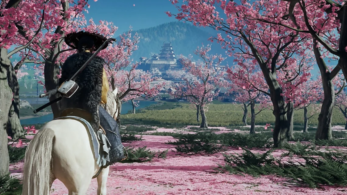 Ghost of Yōtei gameplay image showing a samurai on horseback travelling through pink cherry blossom trees towards a distant Japanese castle in a scenic landscape
