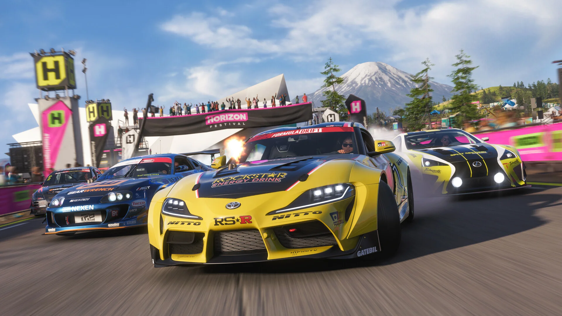 High-speed Forza Horizon 6 gameplay image showing colourful sports cars drifting during a Horizon Festival race with mountains and cheering crowds in the background.