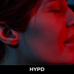 Silent Hill: Townfall character illuminated by an intense red light in a dark and atmospheric scene.