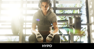 Lucia from GTA 6 sitting in a gym wearing boxing gloves and workout clothing, featured in the latest Grand Theft Auto 6 leaks coverage.
